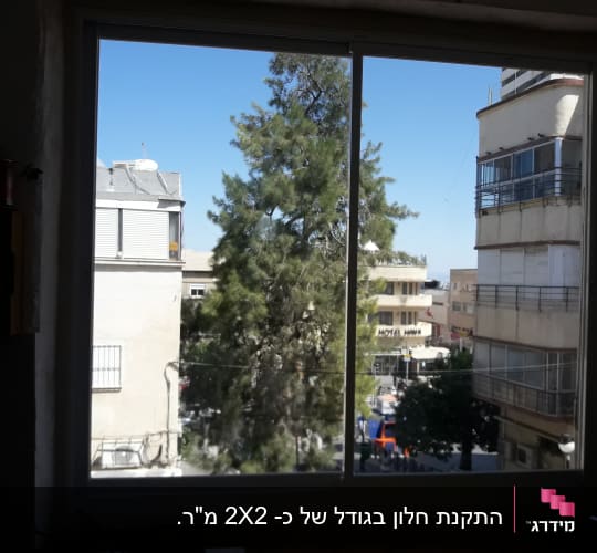 חלון אלומיניום עם נוף עירוני ברקע
